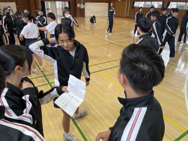 球技大会が始まります。その歓声の中、卒業式のバミりをしている濱口先生。
